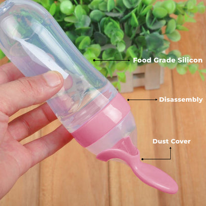 Pink baby food feeder with text labels on a wooden surface