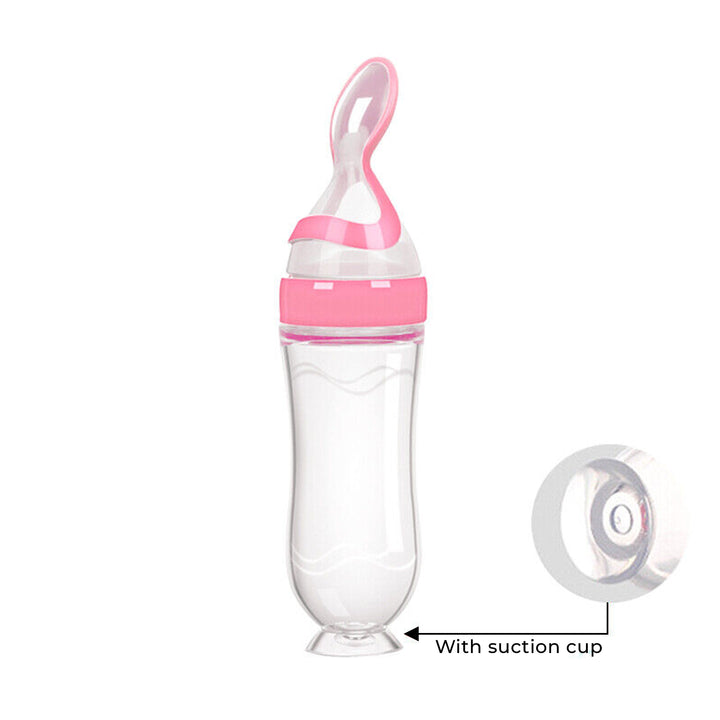 Pink and clear baby feeding bottle with suction cup on a white background