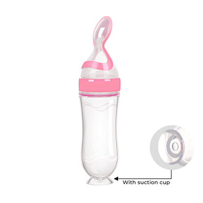 Pink and clear baby feeding bottle with suction cup on a white background