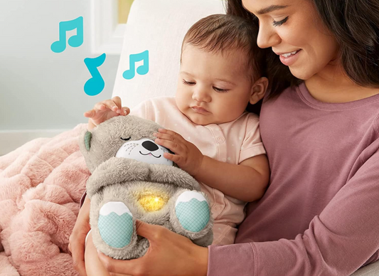 Woman holding a baby and a plush toy with musical notes above them, in a cozy indoor setting.