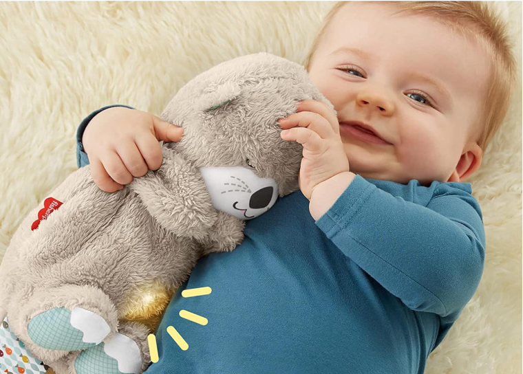 Baby holding a soft toy with a neutral background