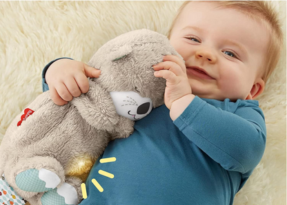 Baby holding a soft toy with a neutral background